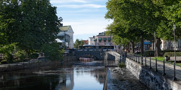 Buss som kör över bro i stadstrafik under sommaren. 